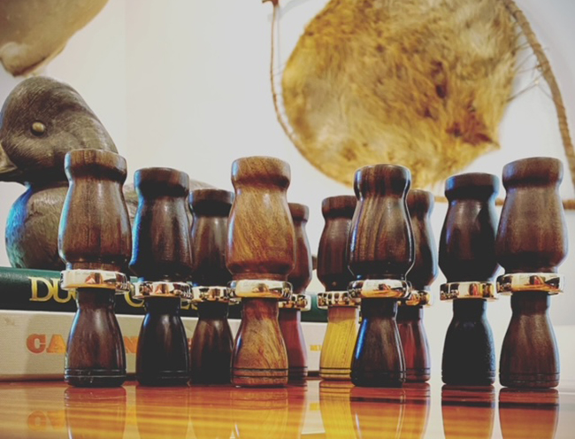 A set of wooden, hand-crafted duck calls can be seen.
