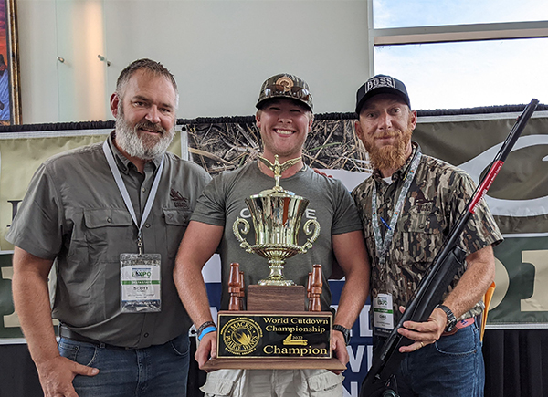 Byron Womack, winner of the 2022 World Cutdown Championship is posing with his trophy and two members of the Delta Waterfowl team.