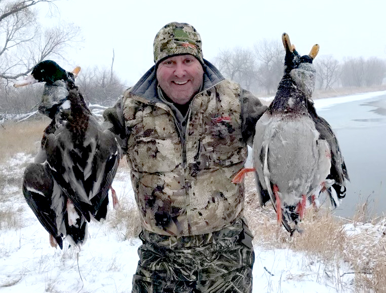 Sean Stone is seen in a wintery landscape, showing off his ducks of the hunt.