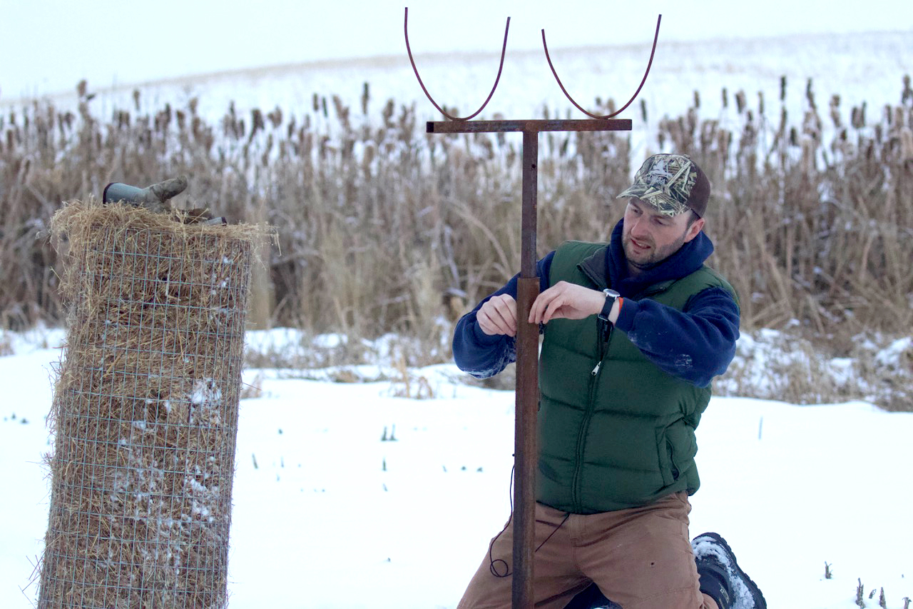 A Delta Waterfowl Hen House installer sets up the base rod for a hen house.
