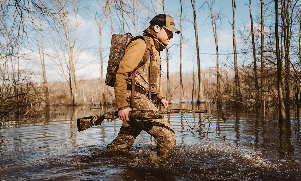 As states finalize waterfowl seasons and regulations for the 2024-25 season, several key changes have come into focus. Hunters like this one, walking through flooded timbers, will have to keep up-to-date, and Delta Waterfowl is here to help you.